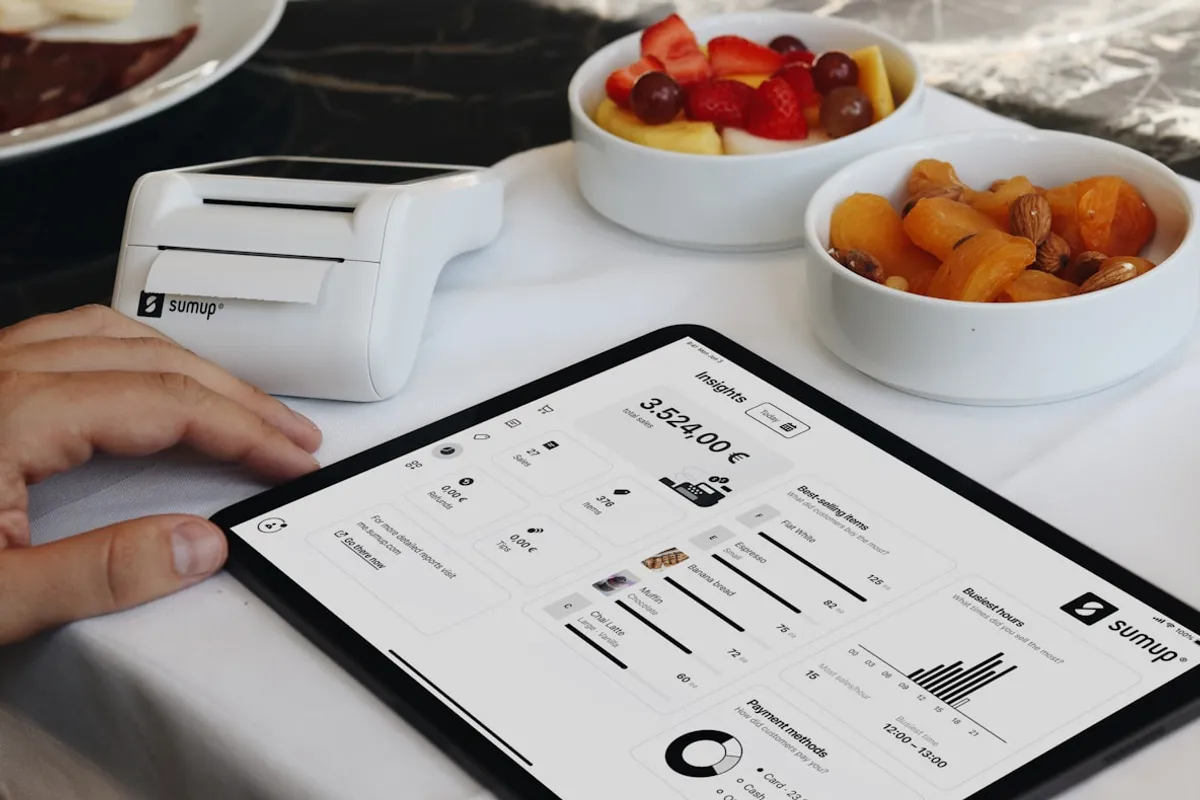 Tablet showing a restaurant sales insights dashboard at the table