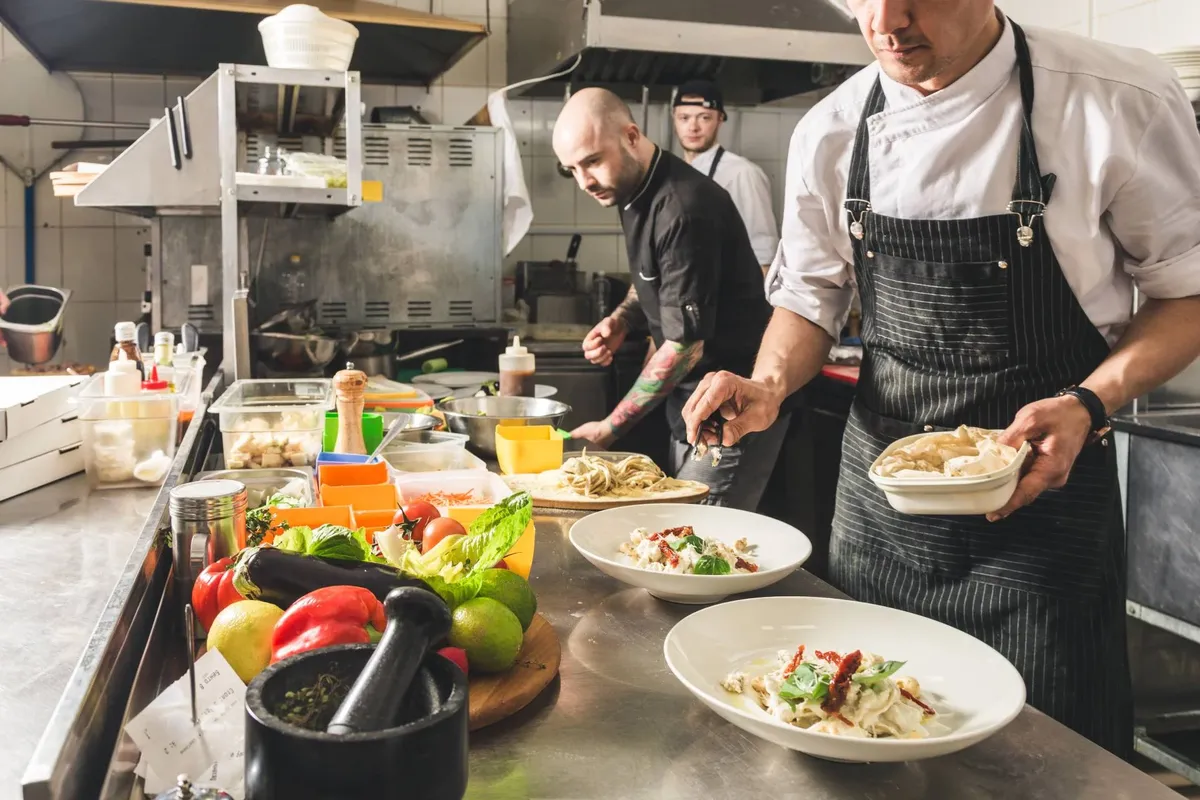 Restaurant kitchen staff preparing and plating dishes